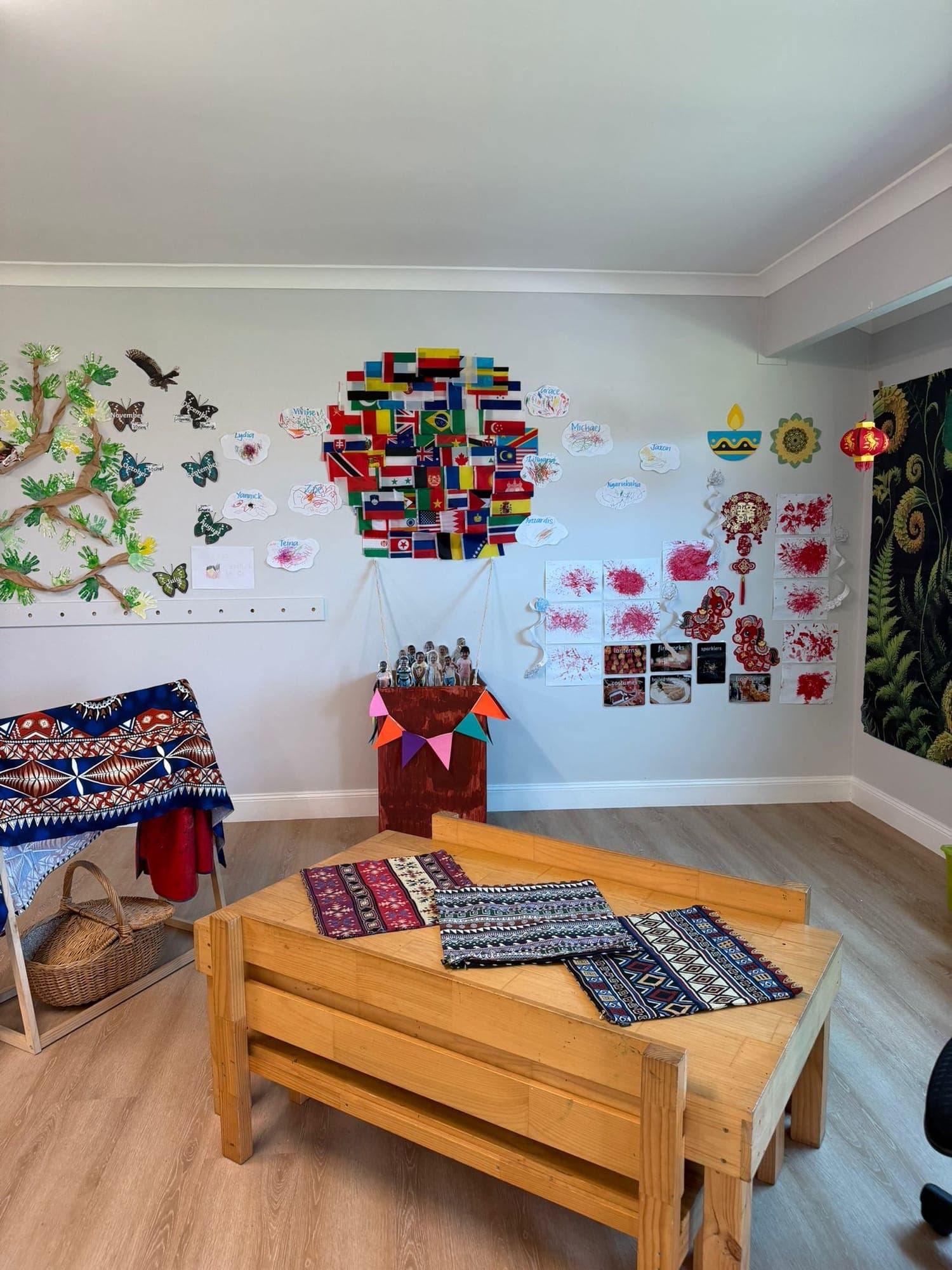 Senior Kindy cultural corner with world flags, woven textiles and a low timber bench